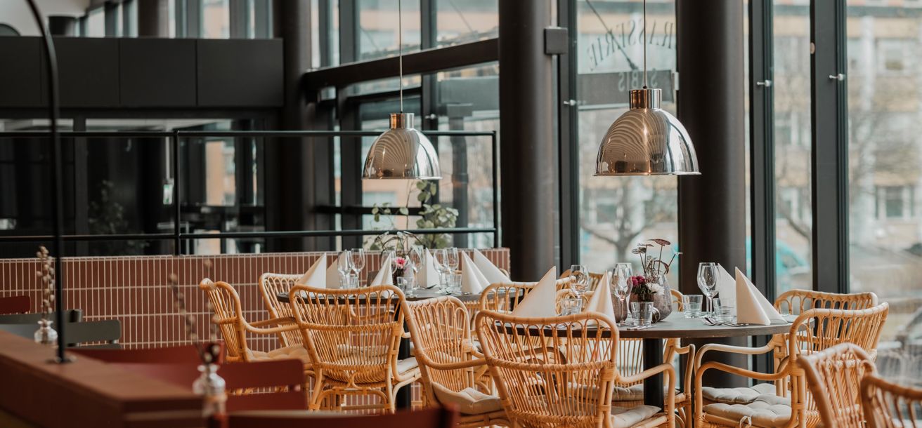 Restaurang med uppdukade bord och korgstolar