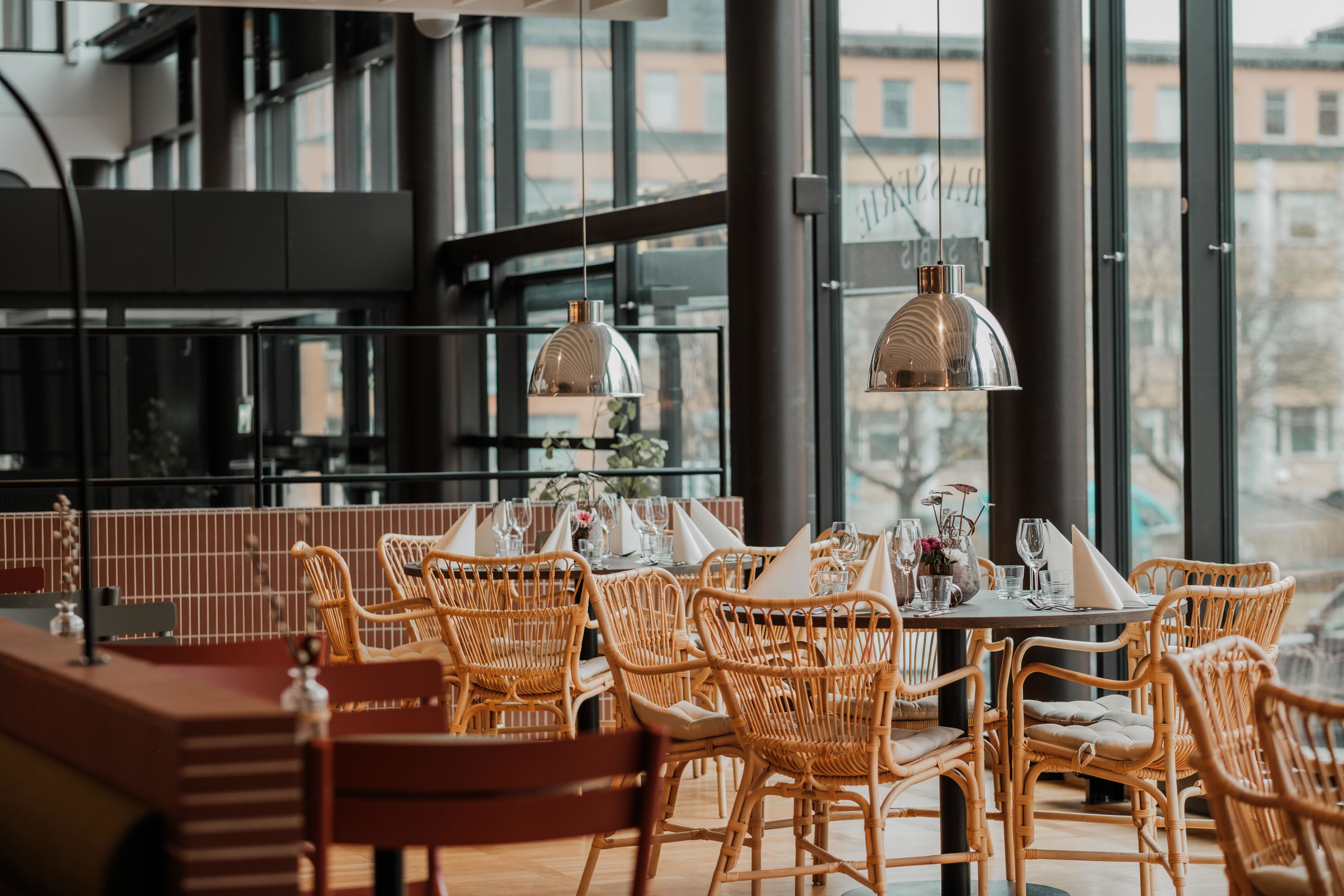 Restaurang med uppdukade bord och korgstolar