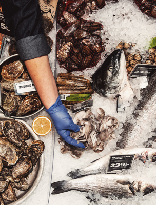 I butikens fiskdisk ligger fiskar och räkor på en isbädd