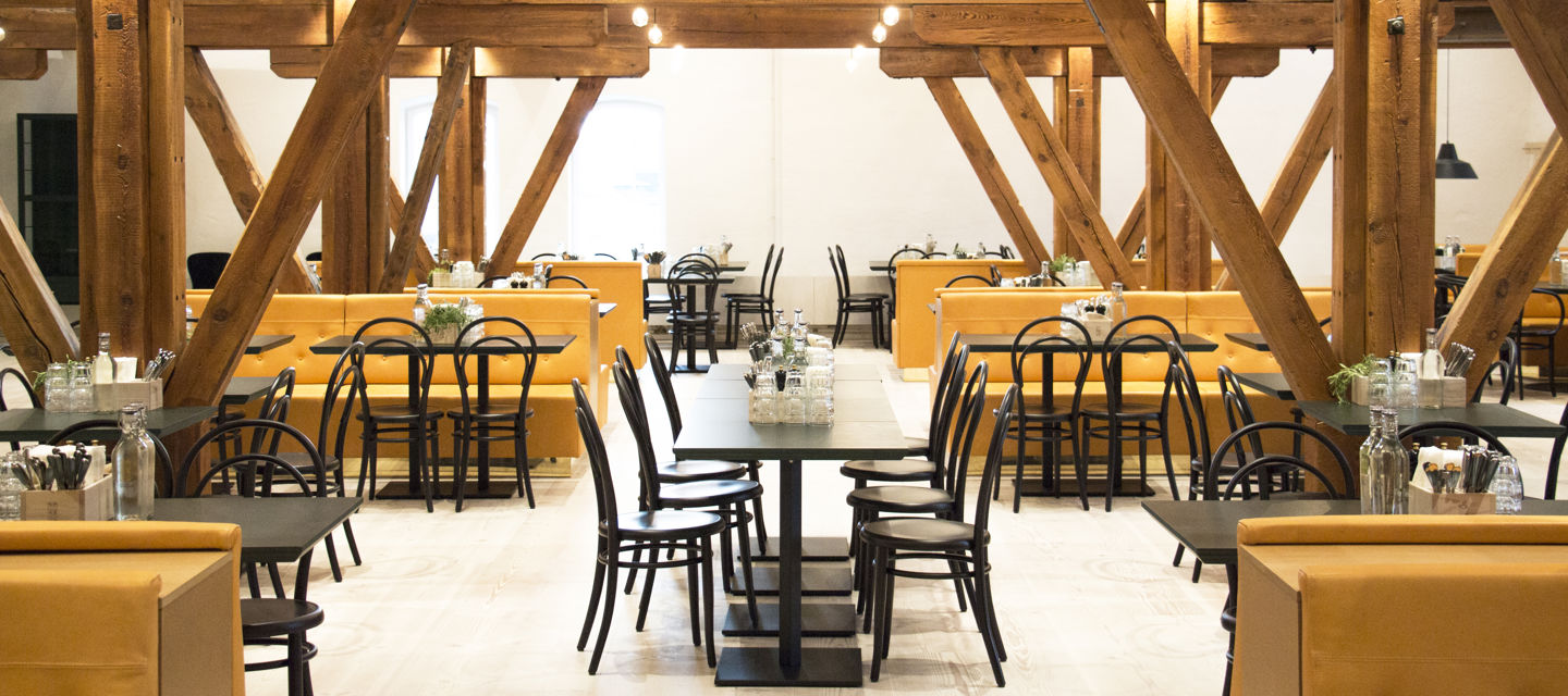 Vacker restaurang med bord och detaljer av trä i taket