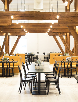 Vacker restaurang med bord och detaljer av trä i taket