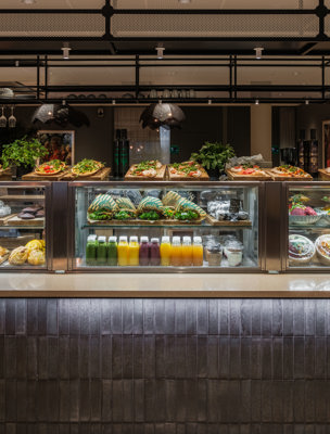 Försäljningsdisk med färgglada juicer, sallader och bakverk