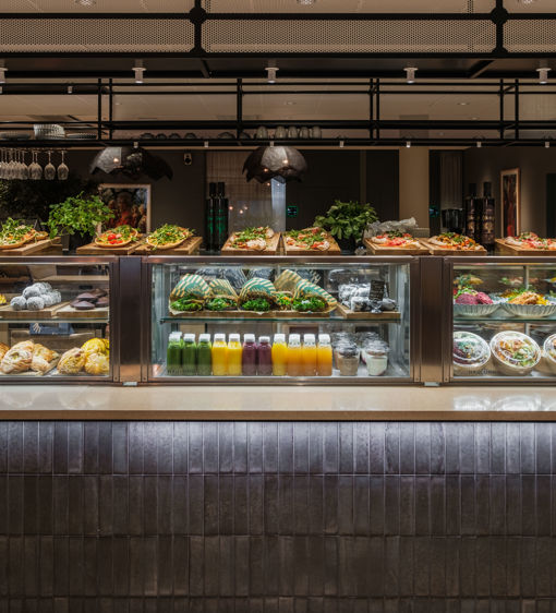 Försäljningsdisk med färgglada juicer, sallader och bakverk