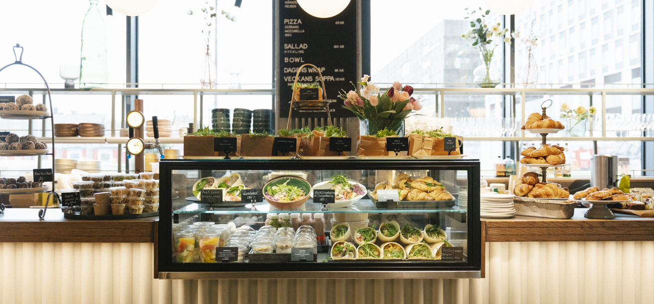 Delidisk fylld med olika maträtter, wraps och fika
