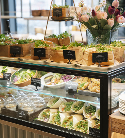 Delidisk fylld med olika maträtter, wraps och färdiga smörgåsar