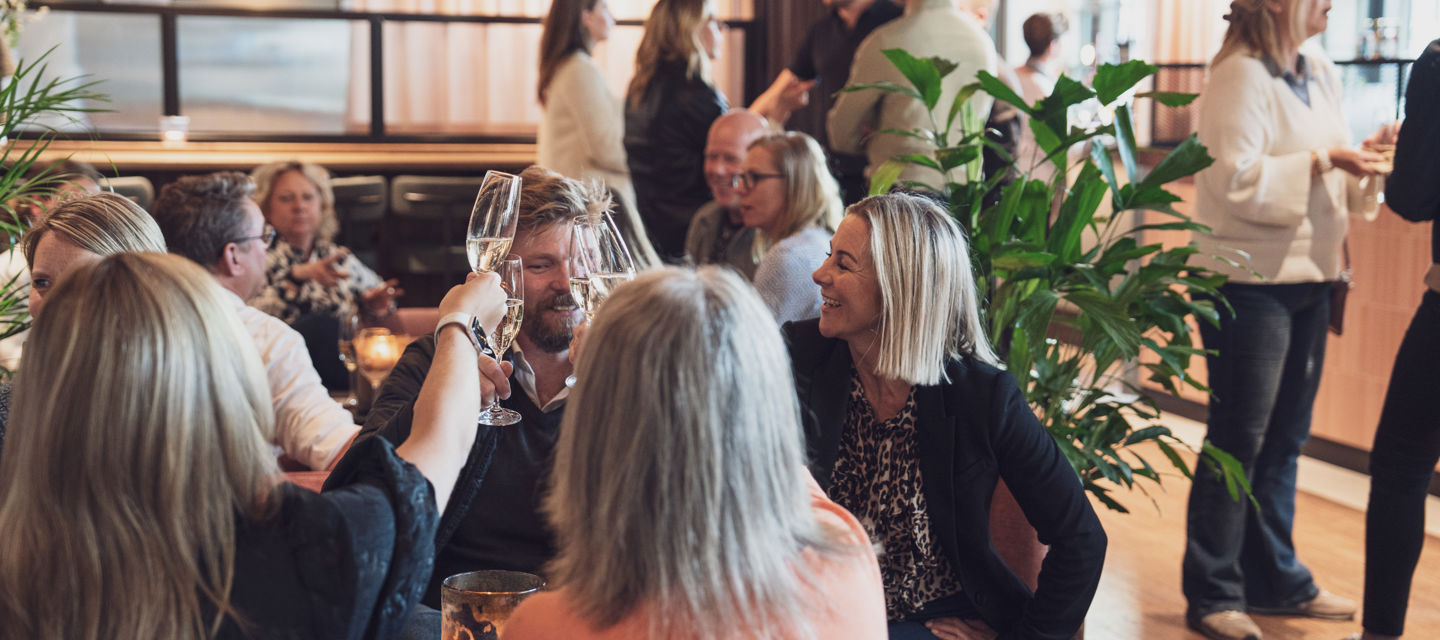 Människor på restaurang skålar i champagne