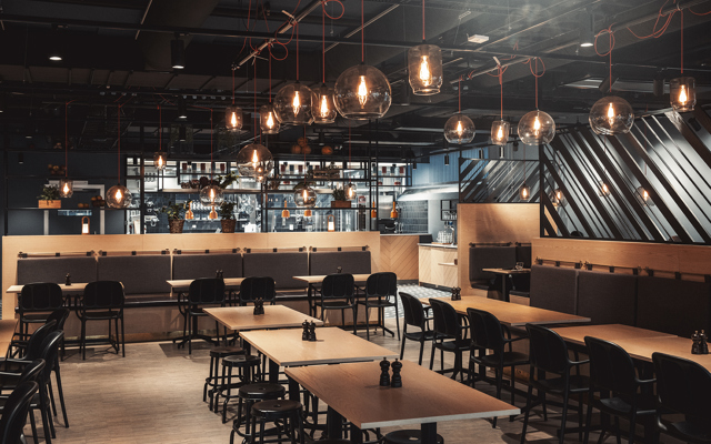 Översikt över restaurangen som har både vanliga bord och barbord