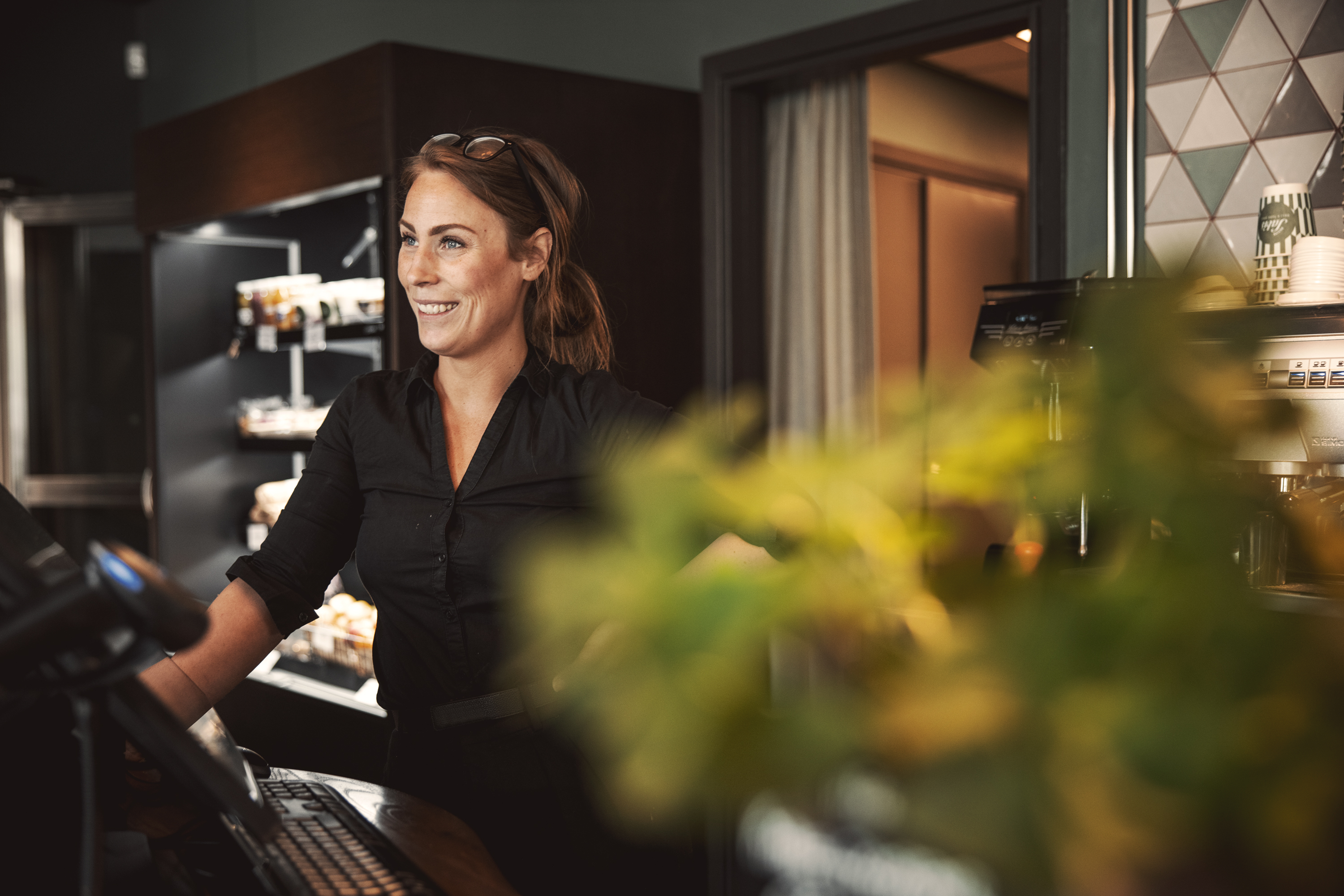 Medarbetare ler bakom kassan