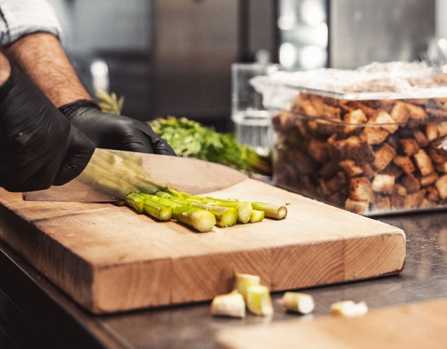 Kock hackar sparris på en skärbräda