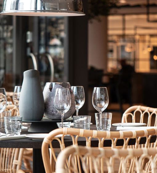 Runt ett dukat bord står det korgstolar