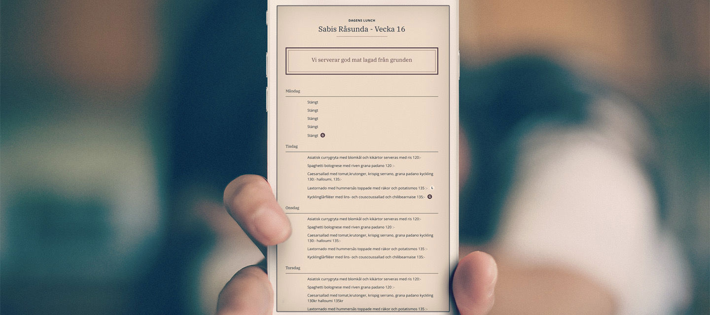 En person håller upp en mobil och på skärmen visas sabis-app