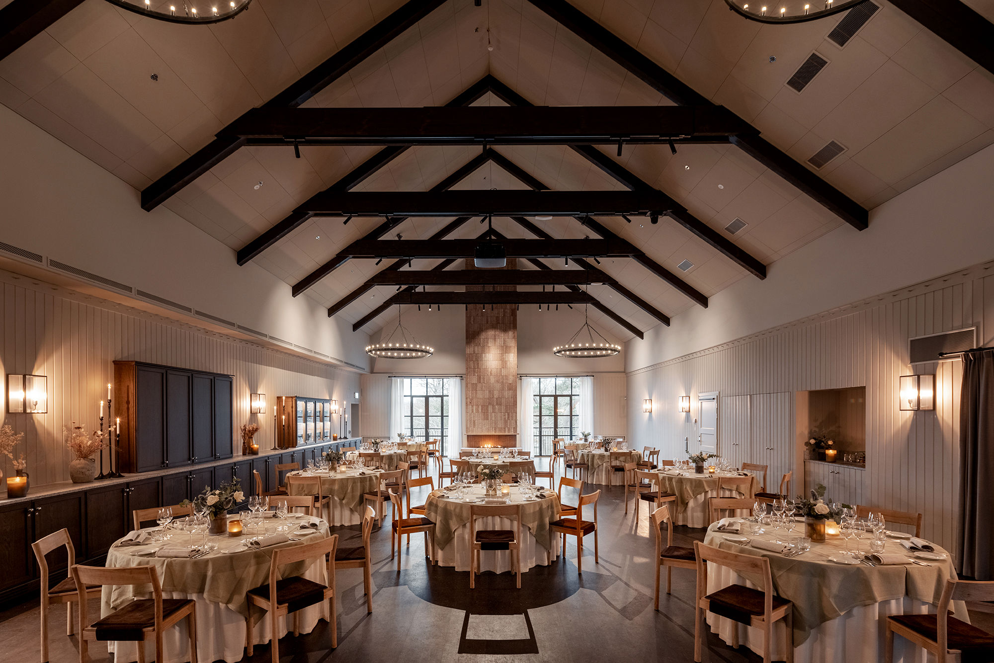 Fest och konferenslokal som är möblerad med runda dukade bord, lokalen har högt i tak