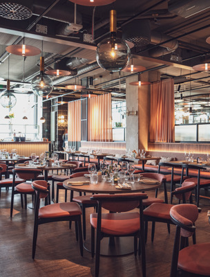 Stor och rymlig restaurang med runda bord och mjuka stolar