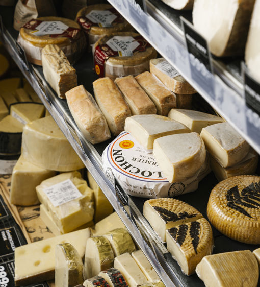 Flera sorters deli ost på hyllor i en butik