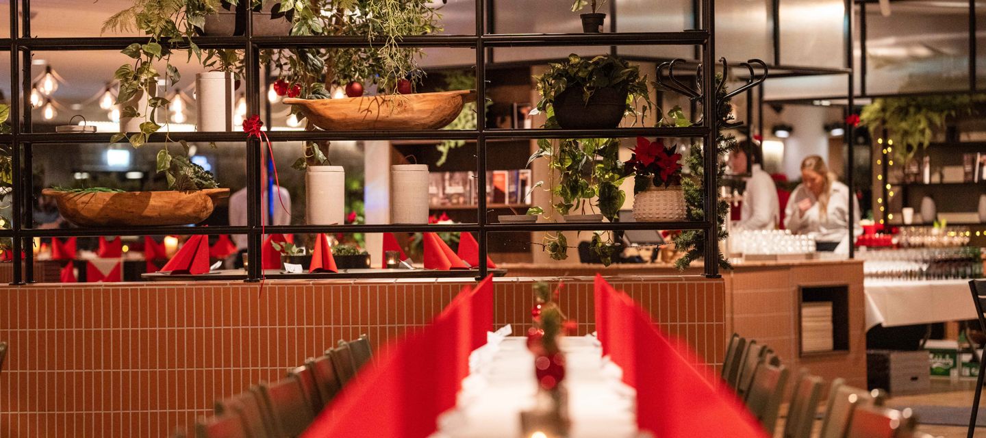 Stor lokal uppdukad för julbord med röda servetter