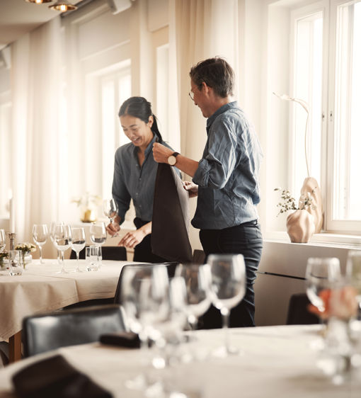 Personal förbereder en festlokal och dukar borden