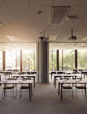 Ljus och luftig konferenslokal möblerad i skolsittning