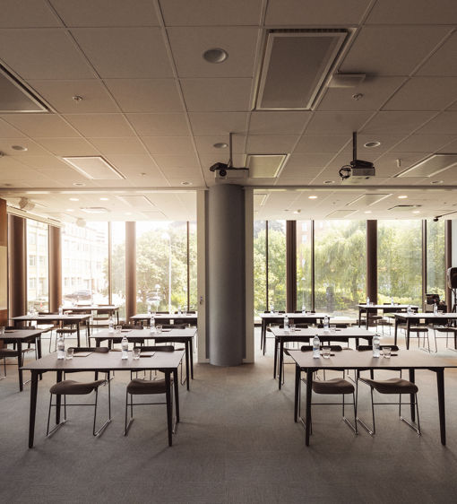 Ljus och luftig konferenslokal möblerad i skolsittning