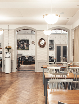 Ljus och öppen lokal med vanliga bord och större bord med barstolar