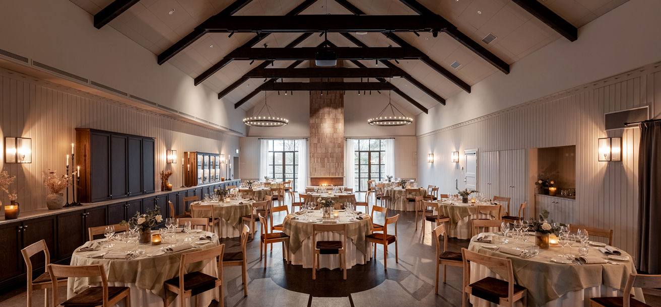 Rymlig festvåning dukad med små runda bord