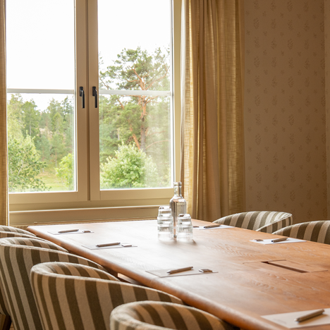 Konferensrum i ljusa färger, möblerad i styrelsesittning