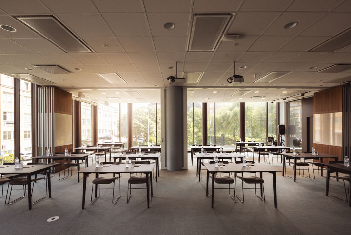 Ljus och luftig konferenslokal möblerad i skolsittning