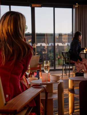 Människor sitter vid bord och i soffor och dricker champagne