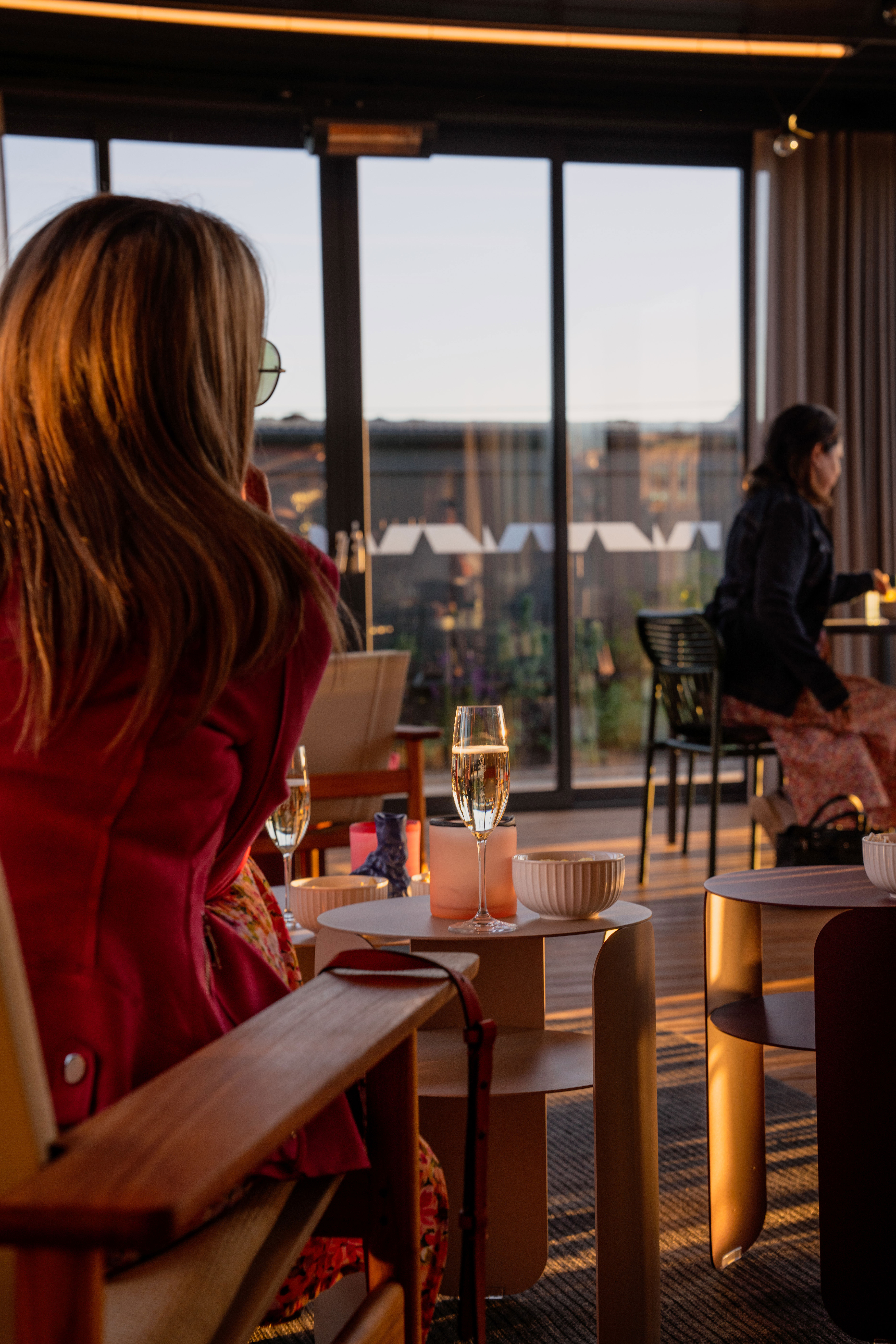 Människor sitter vid bord och i soffor och dricker champagne