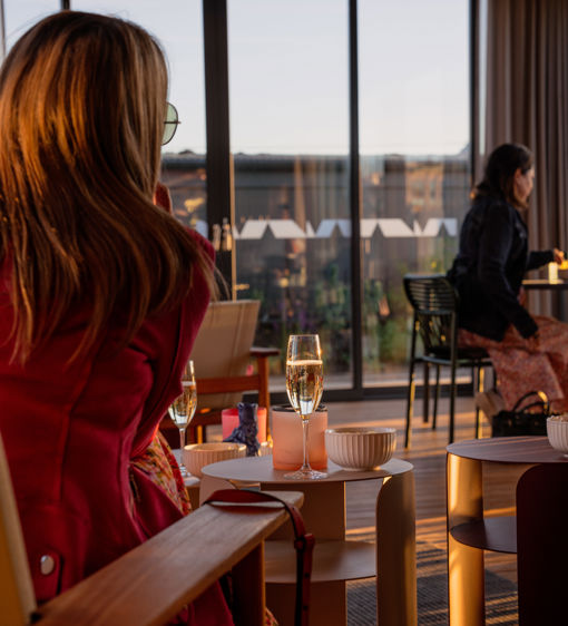 Människor sitter vid bord och i soffor och dricker champagne